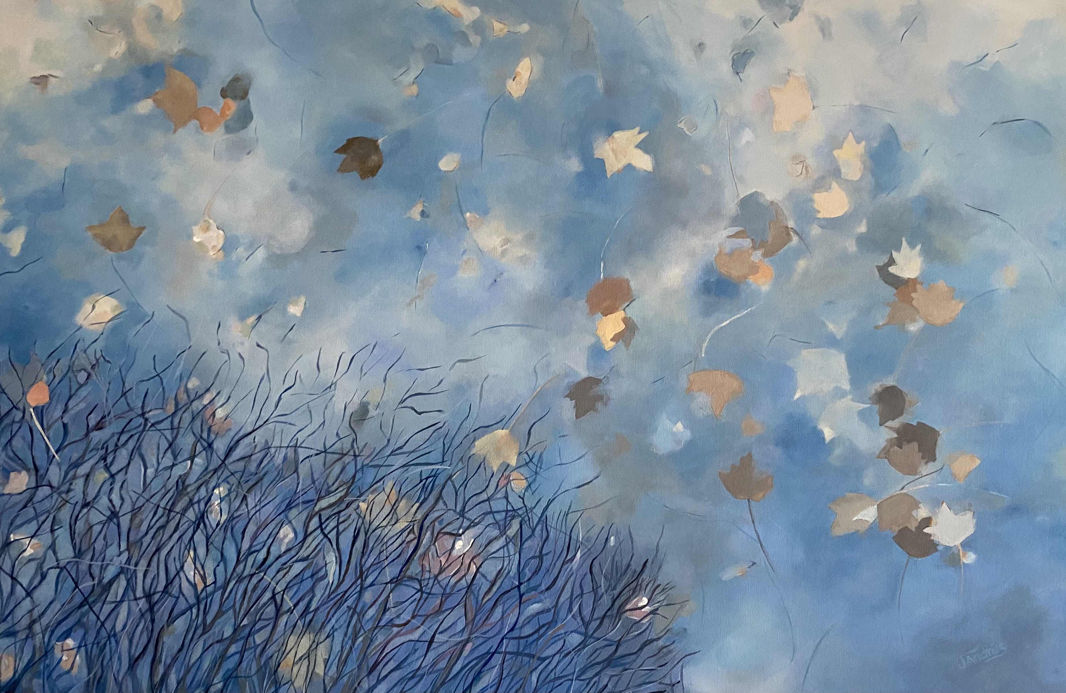 Maple leaves float in a puddle reflecting bare branches and a wispy blue sky